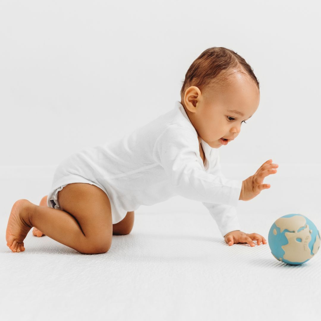 peuter rolt met speelgoed wereldbol