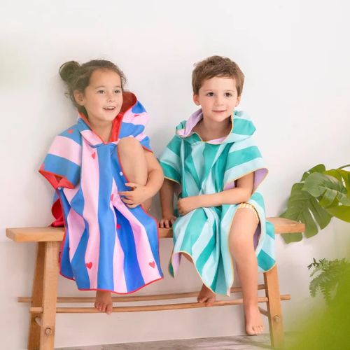 kinderen zitten een knus in poncho